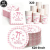 A set of pink bow themed birthday party supplies including cups and plates in pink and white gingham patterns.