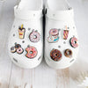 A pair of white Crocs featuring various doughnut-themed charms and decorations.