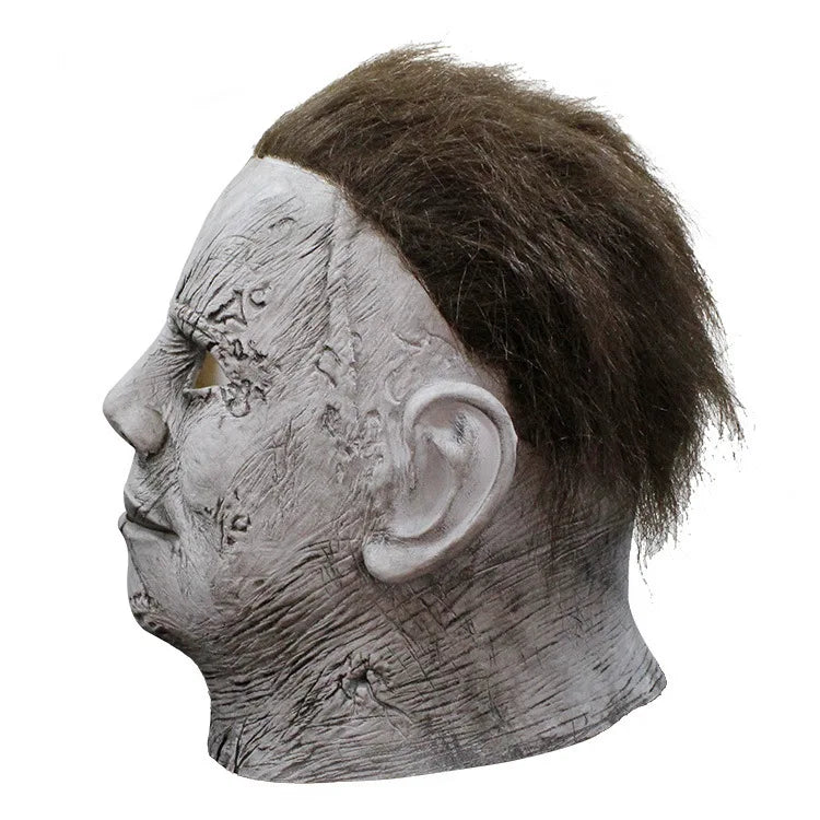 A realistic gray latex horror mask resembling Michael Myers with a shaved head and facial scars.