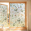 A close-up view of a window with decorative privacy film featuring floral and butterfly patterns.