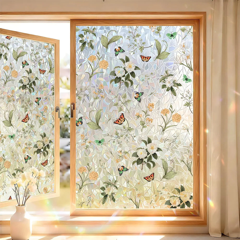 A close-up view of a window with decorative privacy film featuring floral and butterfly patterns.