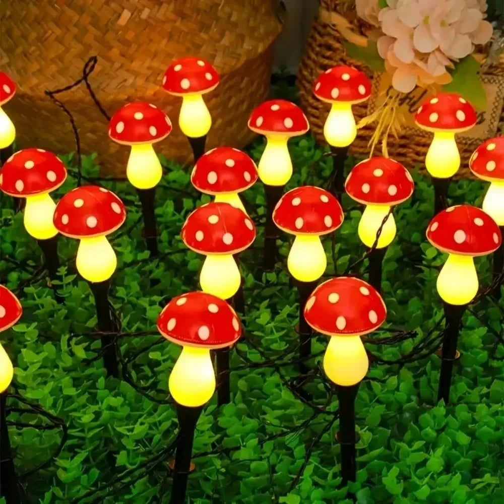 A set of six red and white mushroom-shaped solar garden lights growing in green moss.