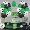 A display of black and green latex balloons, a cake, and soccer balls for a football themed party.