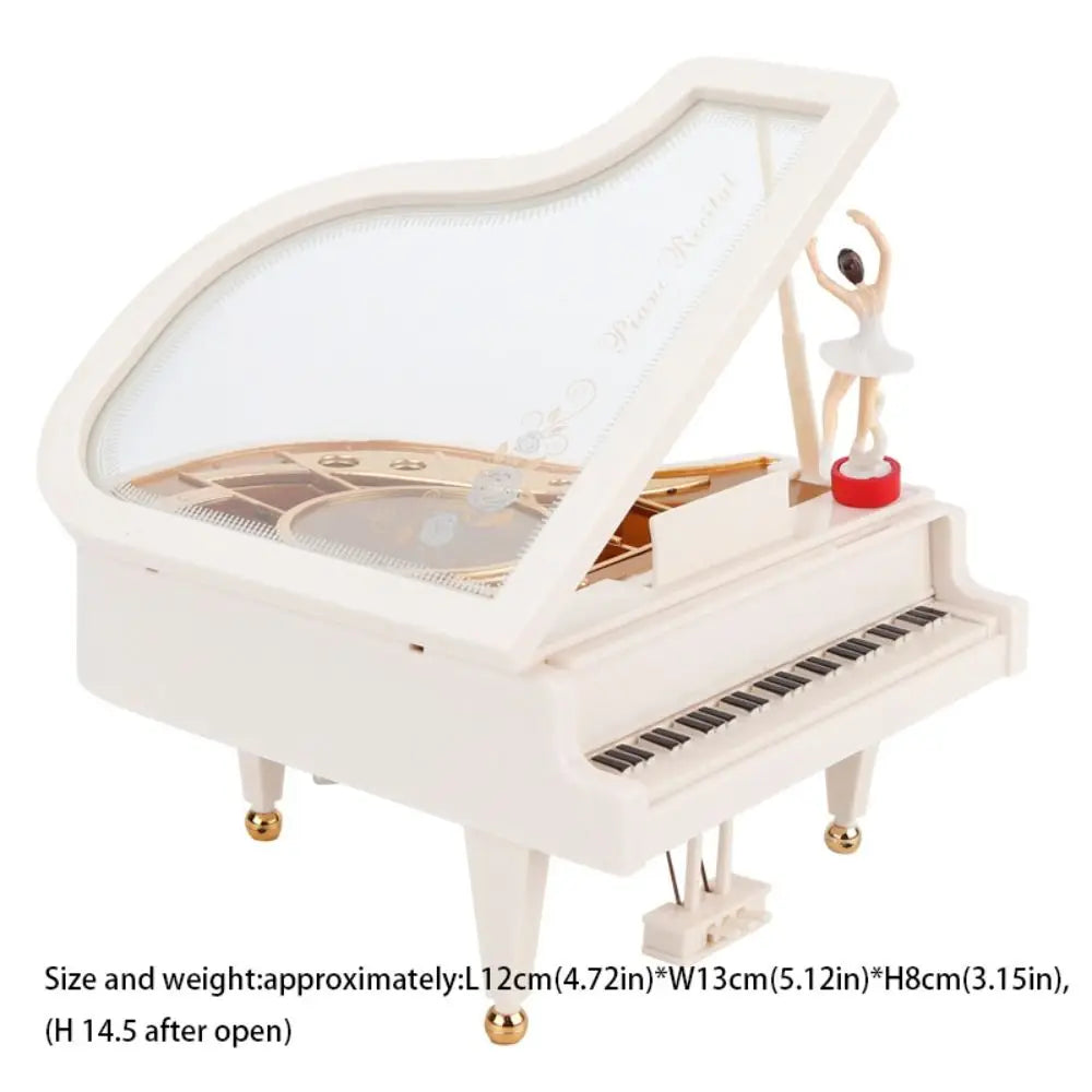 A white hand-crank music box featuring a ballerina figurine and a transparent lid.