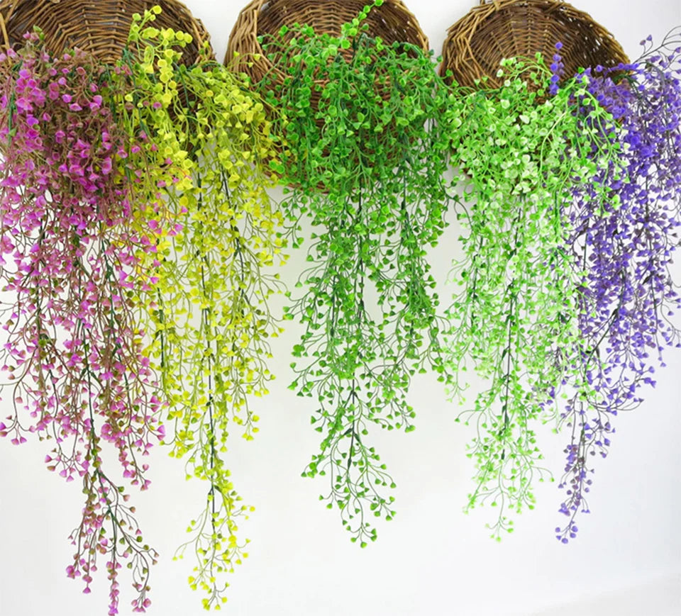 A collection of artificial plant vines in various shades of green, yellow, and purple hanging from a woven basket