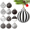 A collection of black and white spherical ornaments featuring polka dots, stripes, and geometric patterns, hanging from a pin