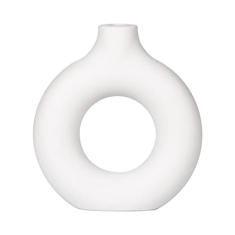 A smooth, white ceramic-look vase with a rounded, organic shape.