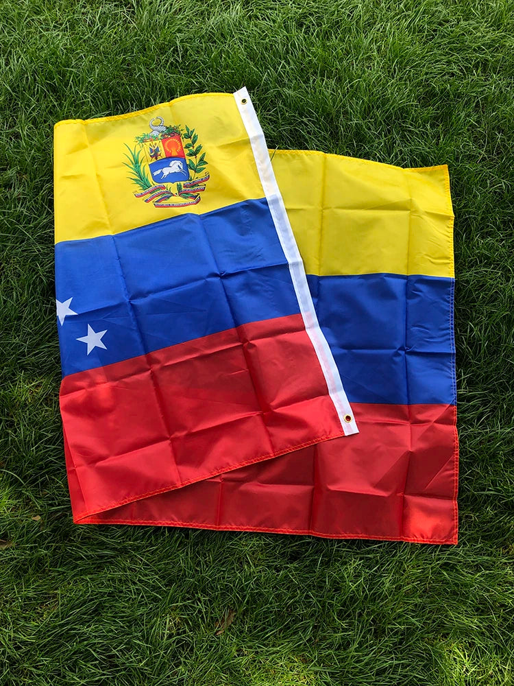 A vibrant Venezuelan national flag banner displayed on green grass.