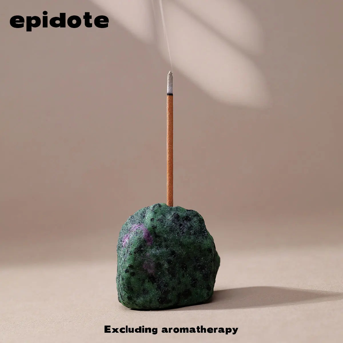 A dark green stone with purple inclusions is shown with a thin stick, likely an incense holder.