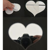 A set of 3D acrylic heart mirror wall stickers shown being held and placed on a dark surface.