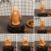 A set of cute little monk resin figurines in orange-brown color displayed on dark wooden bases.