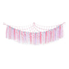 A colorful multi-use storage hammock for toys and plushies made of pink, blue, and purple fabric streamers.