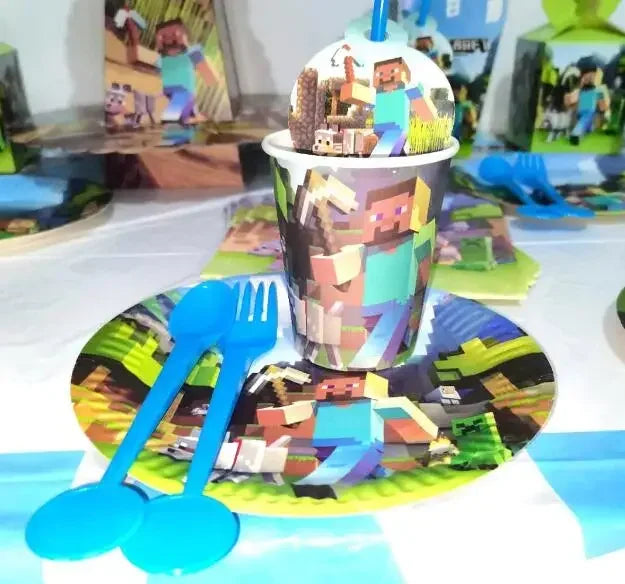 A set of Minecraft-themed party supplies including a flag pulling cake topper and tableware on a white surface.