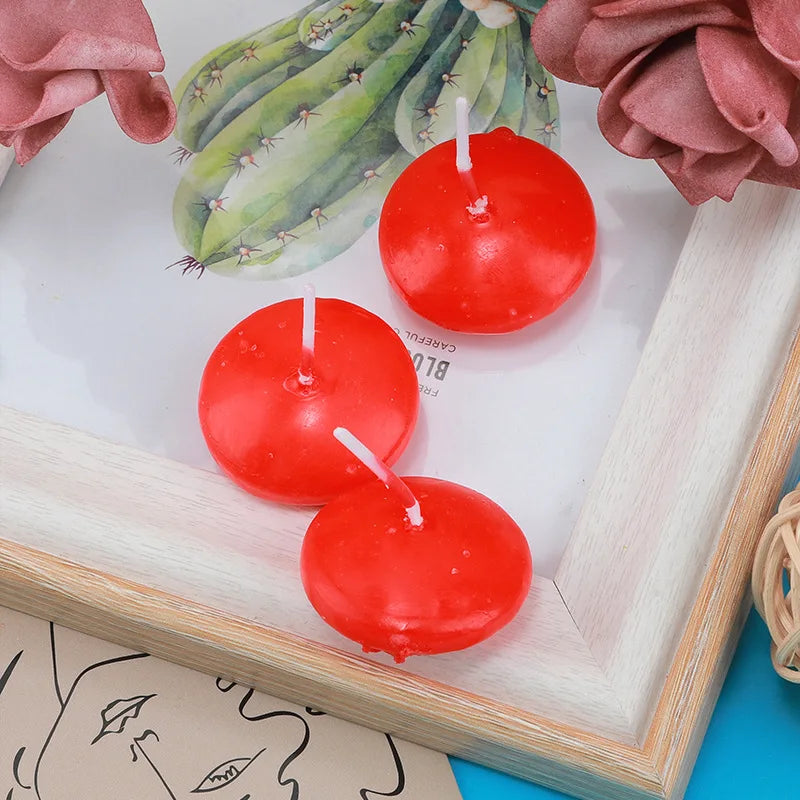 Three red floating candles displayed in a light wood frame with a succulent plant backdrop.