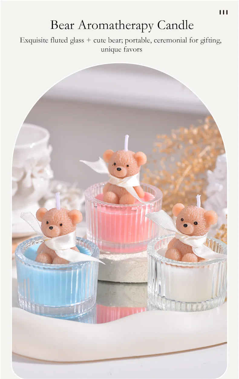 Three bear aromatherapy candles in glass jars with ribbons displayed on a white surface.