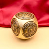 A brass Chinese lucky coin spinner fidget toy with intricate engravings resting on a light background.