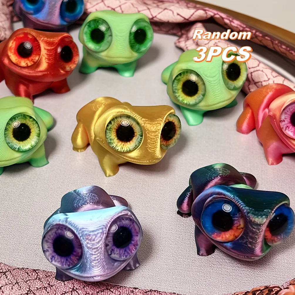 A collection of six 3D printed frog car ornaments with color-shifting eyes in various shades of green, yellow, and pink.