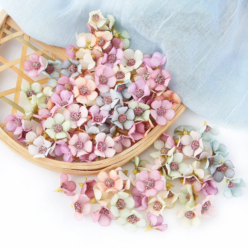 A collection of pink and white silk artificial flower heads arranged on a bamboo tray.
