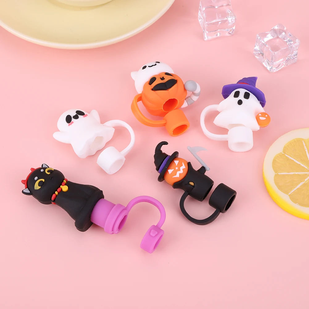 A collection of reusable silicone straw covers shaped like Halloween characters, including a pumpkin and a ghost.