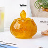 A smooth, amber-colored crystal bowl with a pointed top sits on a white surface.