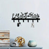 Black Islamic Arabic blessing key holder with hooks mounted on a white wall.