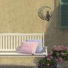 A wall decor sculpture featuring a black cat silhouette and crescent moon design on a beige wall.