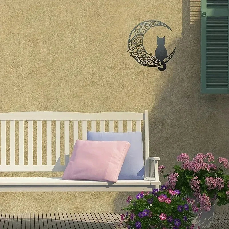 A wall decor sculpture featuring a black cat silhouette and crescent moon design on a beige wall.