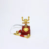 A vintage rotary desk phone miniature decor with a red base and gold-colored handset.