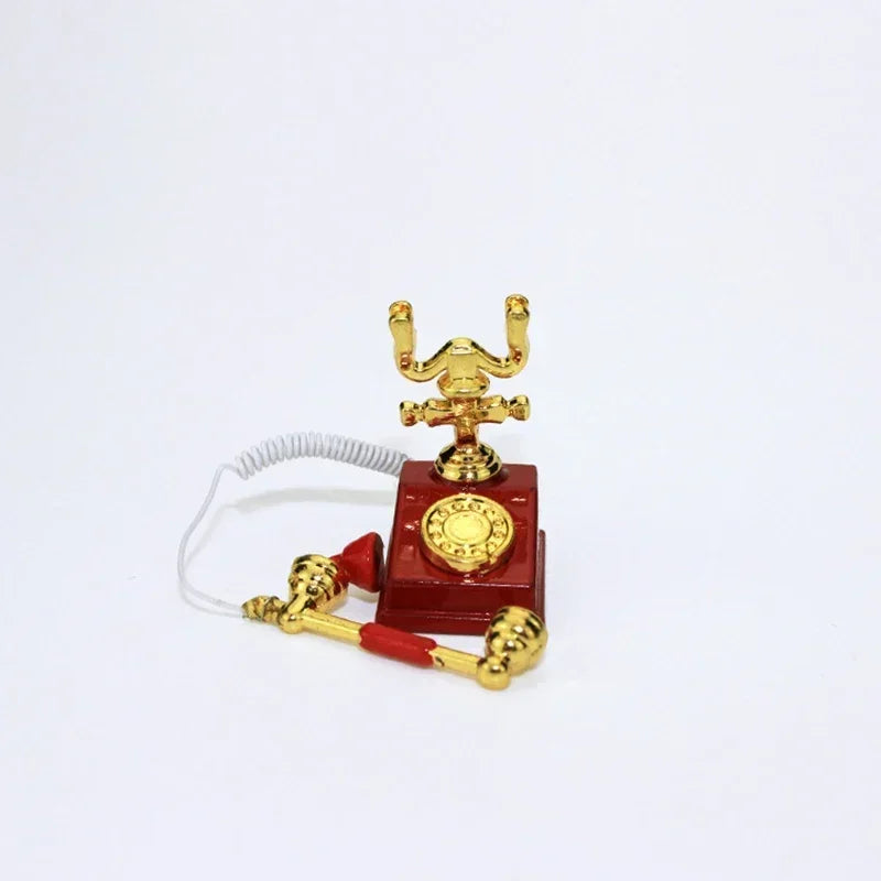 A vintage rotary desk phone miniature decor with a red base and gold-colored handset.