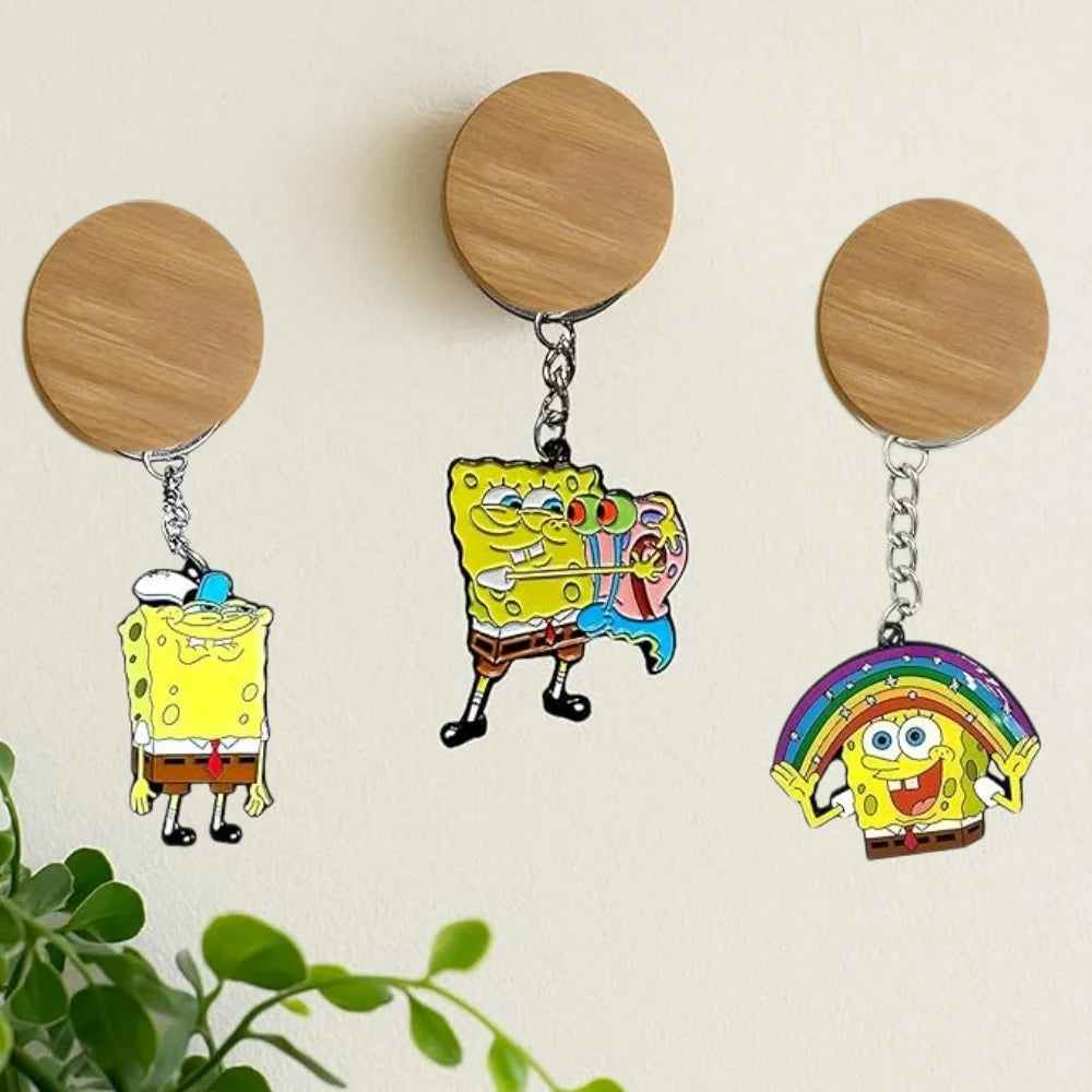 A set of three SpongeBob SquarePants cartoon keychains with round wooden discs and silver chains.