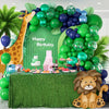 A vibrant green balloon arch set decorated with tropical leaves and a lion figure for a birthday celebration.