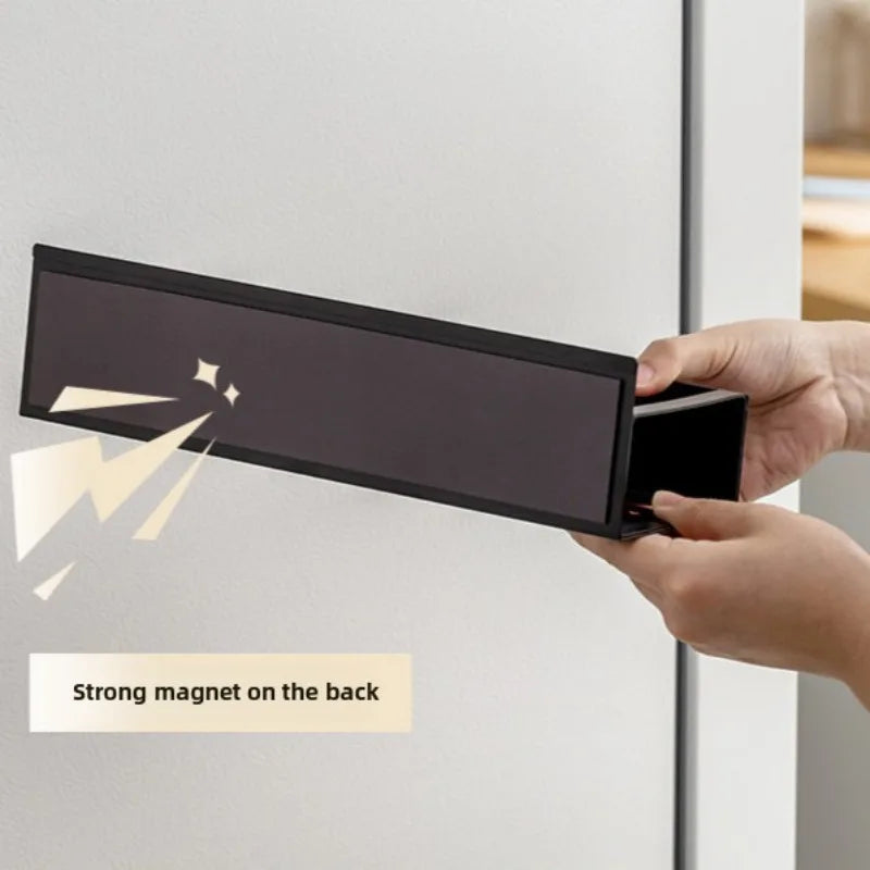 A hand is holding a black magnetic spice rack designed to attach to a refrigerator, showing its design and strong magnet feat