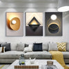 Modern geometric canvas wall art featuring three framed abstract pieces with gold and black tones.