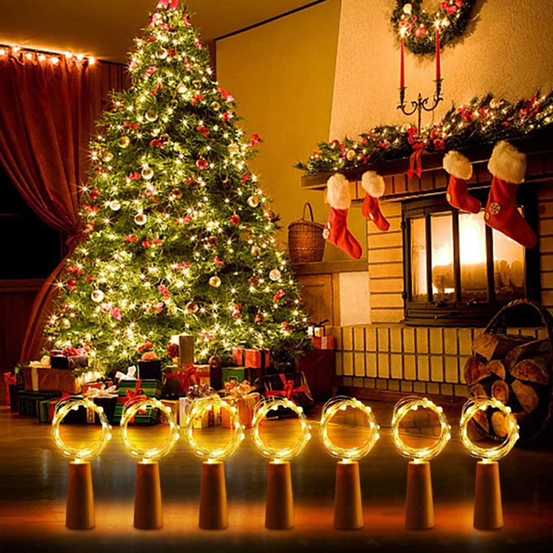 A festive Christmas scene featuring a decorated tree and ten glowing LED wine bottle cork lights.