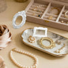A collection of vintage resin picture frames, including a white oval frame and gold circular frames, displayed on a marble tr