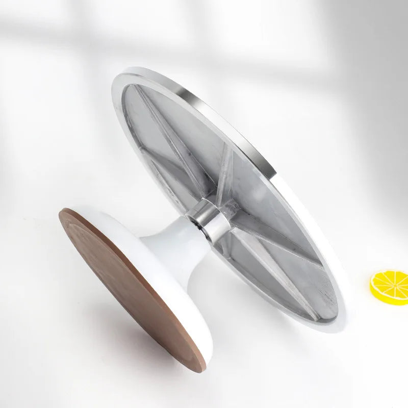 A silver aluminum cake turntable with a white base and wooden top, shown in a bright, minimalist setting.