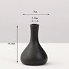 A matte black ceramic vase with a tapered neck and wide base, shown against a white background.