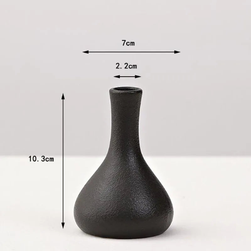 A matte black ceramic vase with a tapered neck and wide base, shown against a white background.