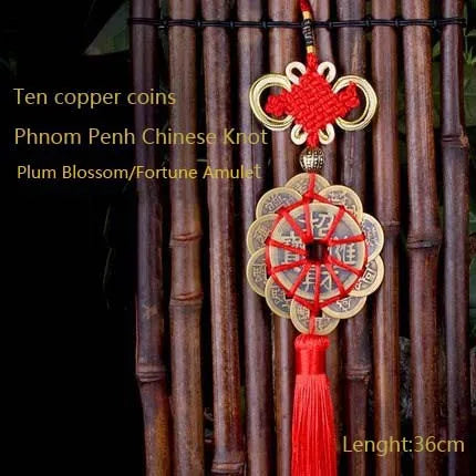 Ten copper coins and a plum blossom fortune amulet pendant with a Chinese knot hanging from bamboo rods.