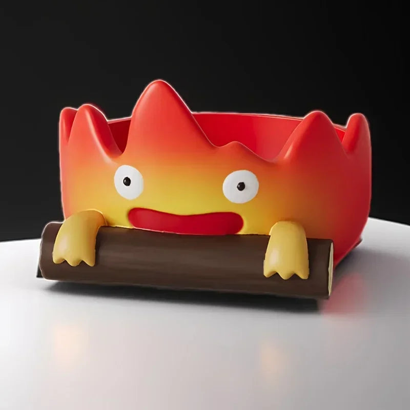 A resin cartoon fire person shaped like a flame is resting on a brown tray.