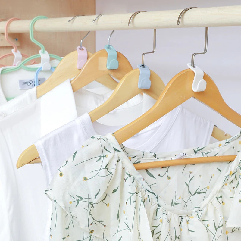 A set of space-saving hanger connector hooks is displayed hanging on a wooden rack.