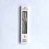 A vertical box of rainbow candle sticks with a silver metallic curve design for a birthday celebration.