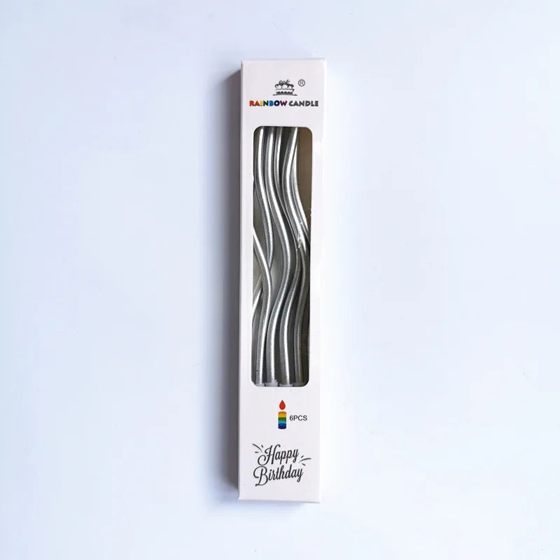 A vertical box of rainbow candle sticks with a silver metallic curve design for a birthday celebration.