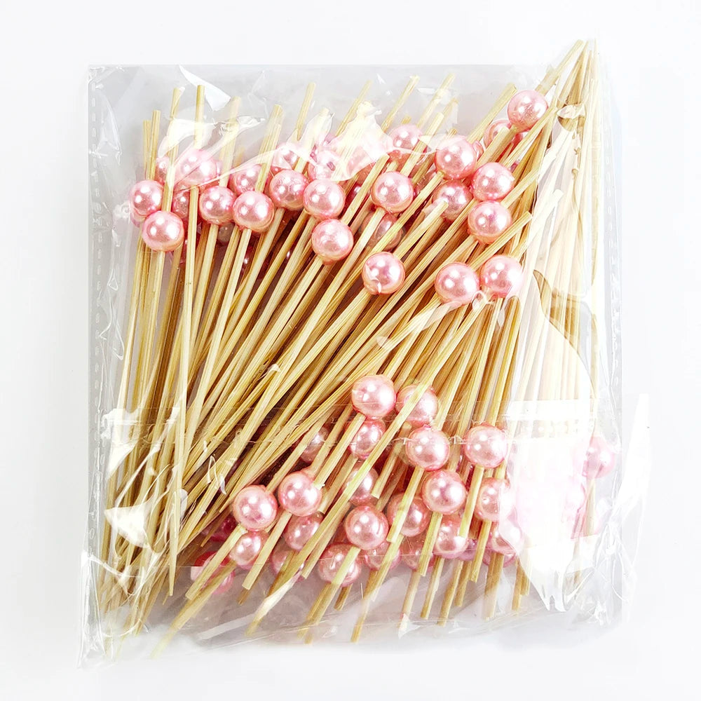 A bundle of pearl-tipped bamboo cocktail picks with a white pearl finish in clear packaging.