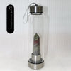 Botella de agua de vidrio con tapa de plata y columna de cristal natural en su interior.