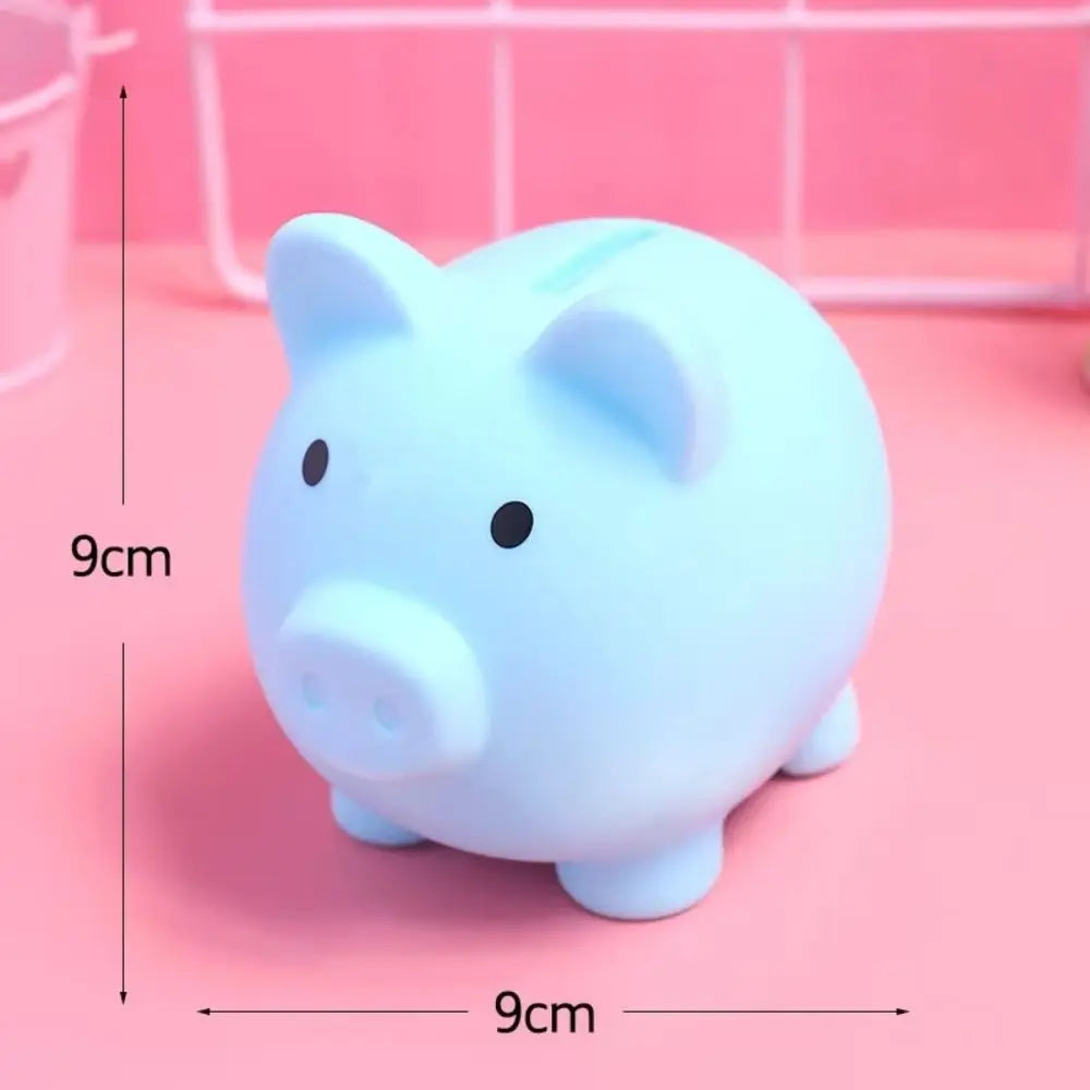 A light blue pig-shaped coin storage bank is shown against a pink background.