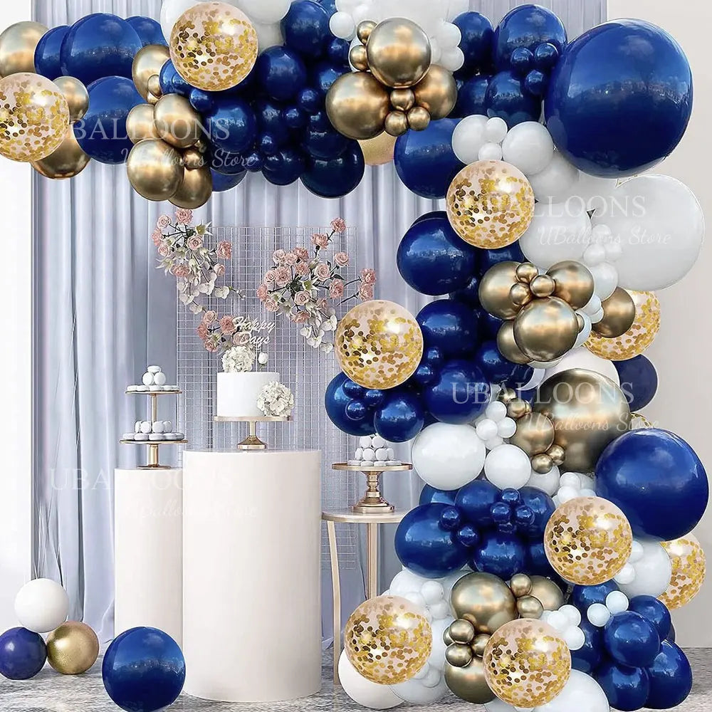 A balloon arch display featuring navy blue and gold balloons with metallic and pearl finishes.
