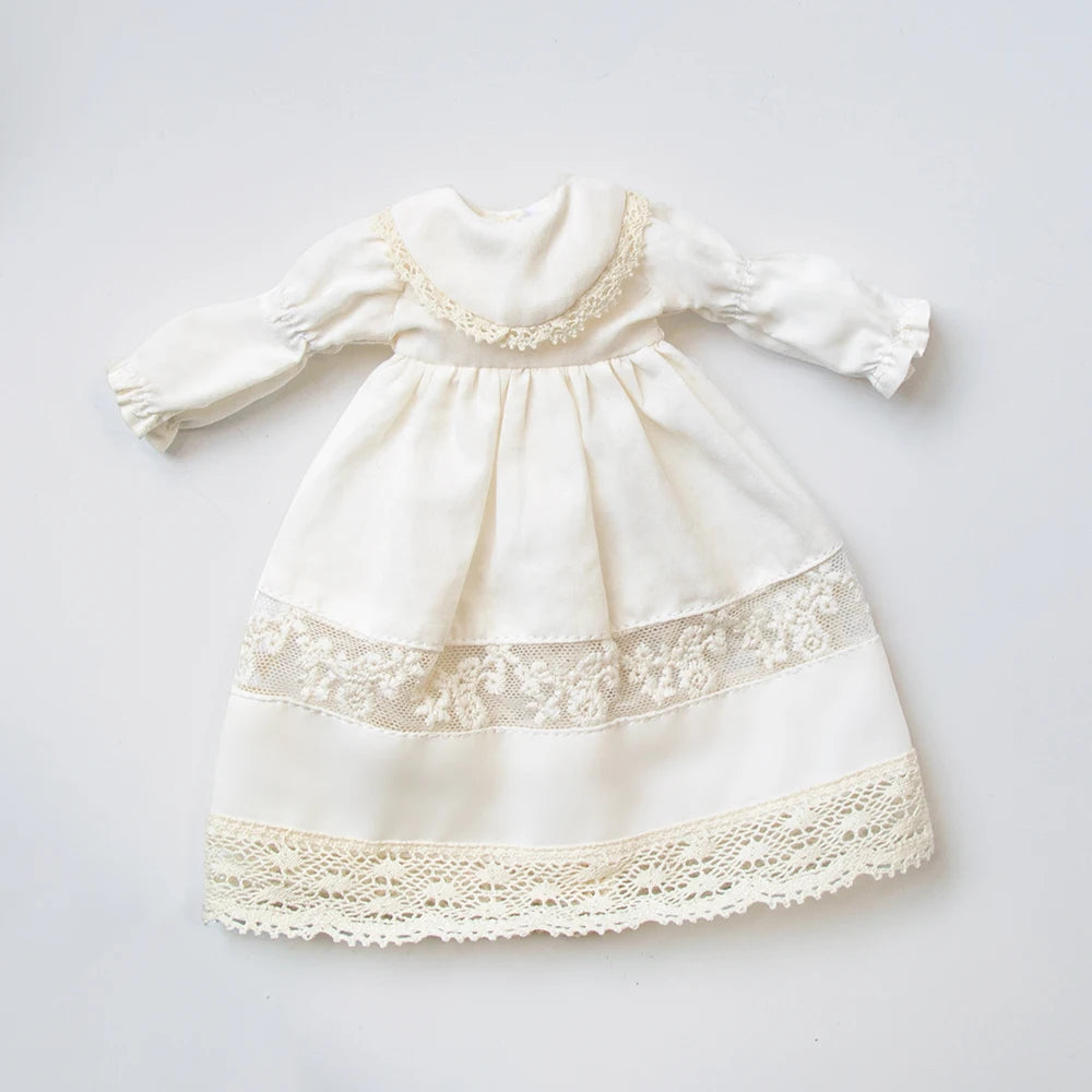A vintage white lace pajama set for a doll featuring delicate embroidery and eyelet trim.
