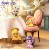 A collectible figurine of a pony character with pink and yellow features sitting on a wooden box.