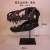 A black resin sculpture of a Tyrannosaurus skull displayed on a stand.